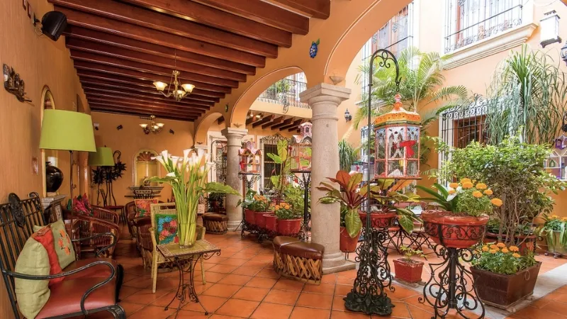 Image of the internal courtyard areas of Hotel Boutique Parador San Miguel Oaxaca, showing many plants statues and other decorations