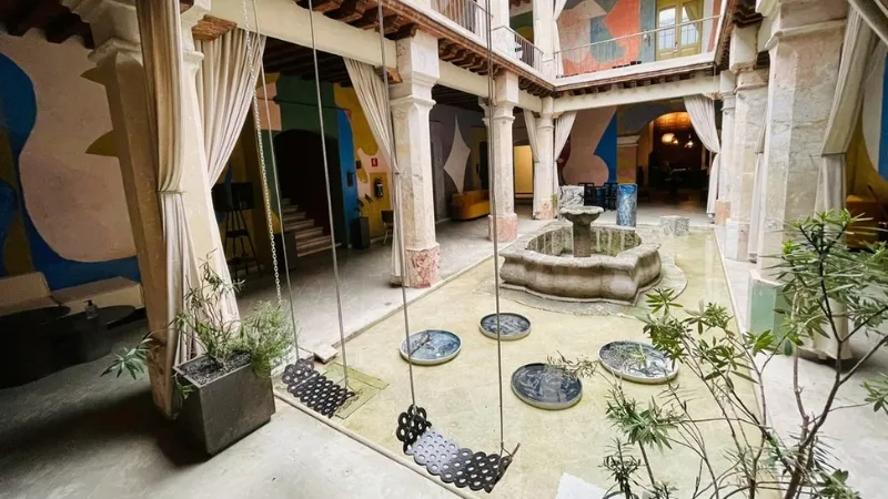 Image of the internal courtyard area of the Pug Seal hotel in Oaxaca with swings in the foreground