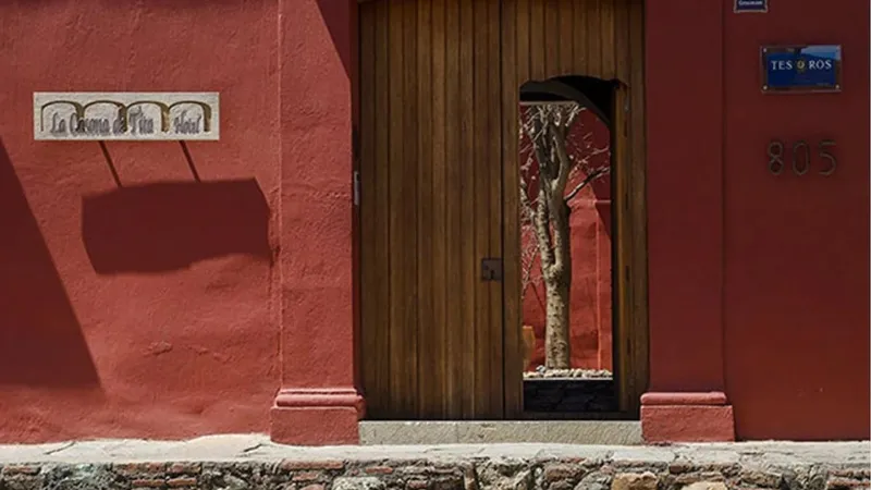 Deep pink walls of the entrance to Hotel La Casona De Tita in Oaxaca City, taken from the street