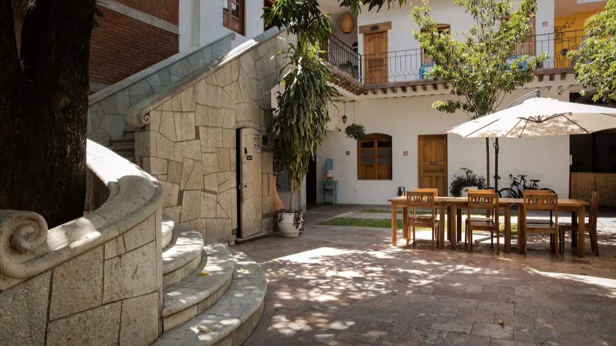 The inner courtyard of the NaNa Vida Hotel Oaxaca with stone stairway leading up to upper levels in the foreground.