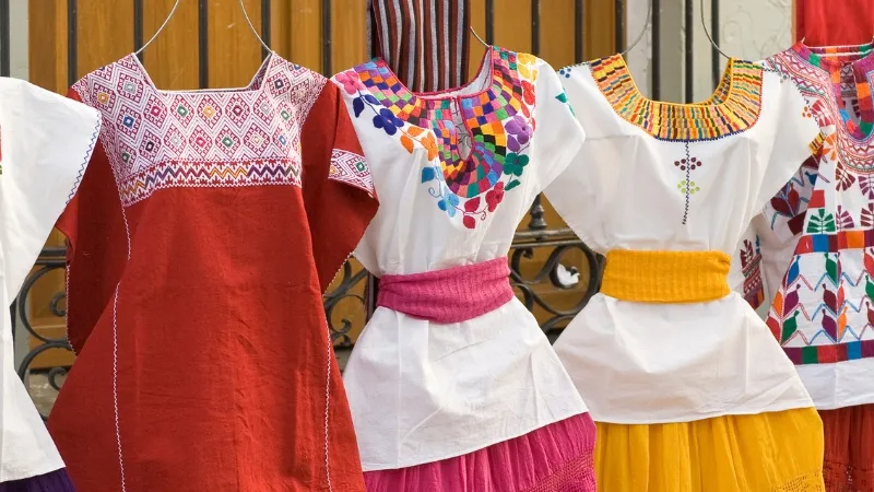 Colorful handmade dresses in traditional Oaxacan style with handmade embroidery around the neck in Oaxaca, Mexico